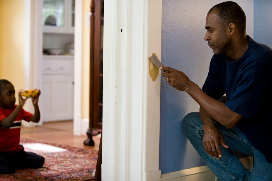 Person inspecting and working on an interior wall area in a home